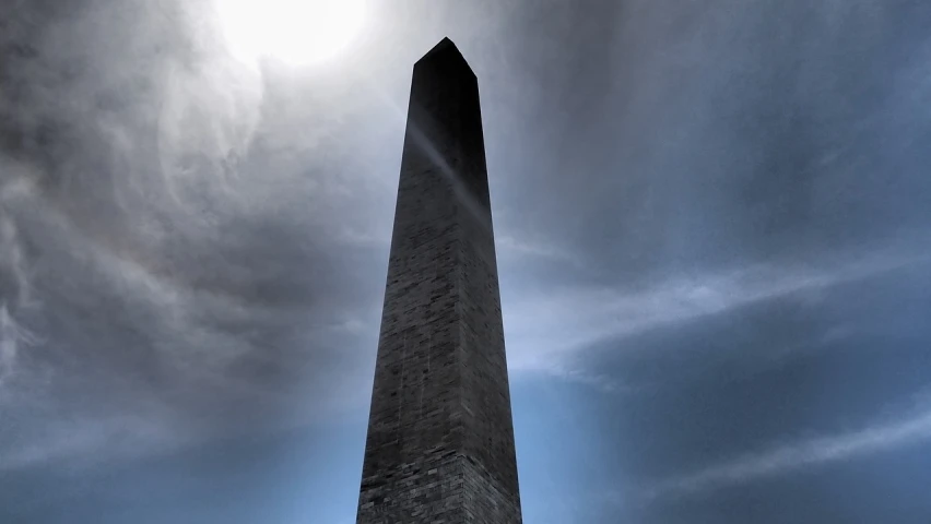 a tall tower with a clock on top of it, a picture, by Jon Coffelt, minimalism, obelisk, destroyed washington dc, sun glare, under blue clouds