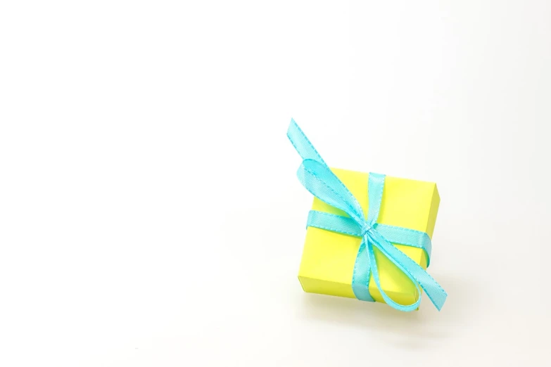 a yellow gift box with a blue ribbon, a stock photo, minimalism, cyan colors, (((yellow))), taken with canon 8 0 d, background is white