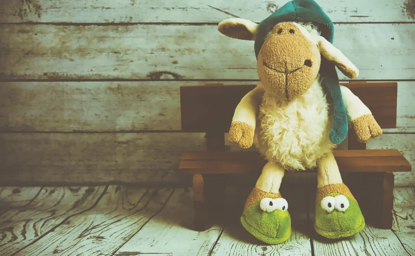 a stuffed sheep sitting on top of a wooden bench, trending on pixabay, peepo the frog!!!, vintage color, 😃😀😄☺🙃😉😗, uncropped