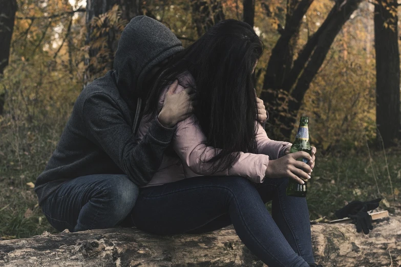 a couple of people that are sitting on a log, pexels, romanticism, portrait of an alcoholic, black haired girl wearing hoodie, crying and reaching with her arm, 4 0 9 6