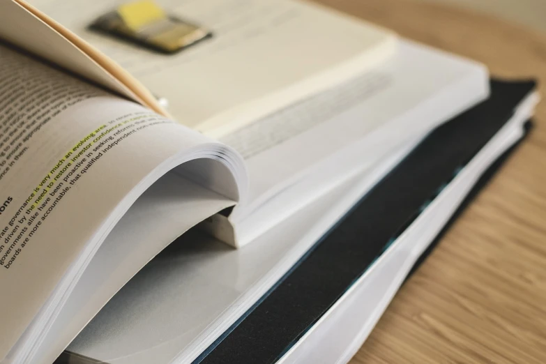 an open book sitting on top of a wooden table, a picture, technical document, magazine sales, rounded corners, up close picture