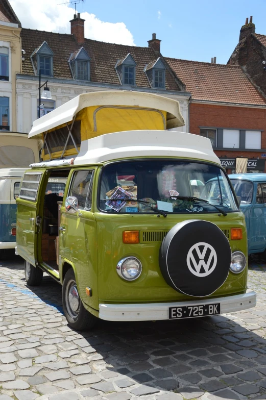 a green vw bus parked on a cobblestone street, shutterstock, tent, 7 0 s photo, northern france, green pickup car