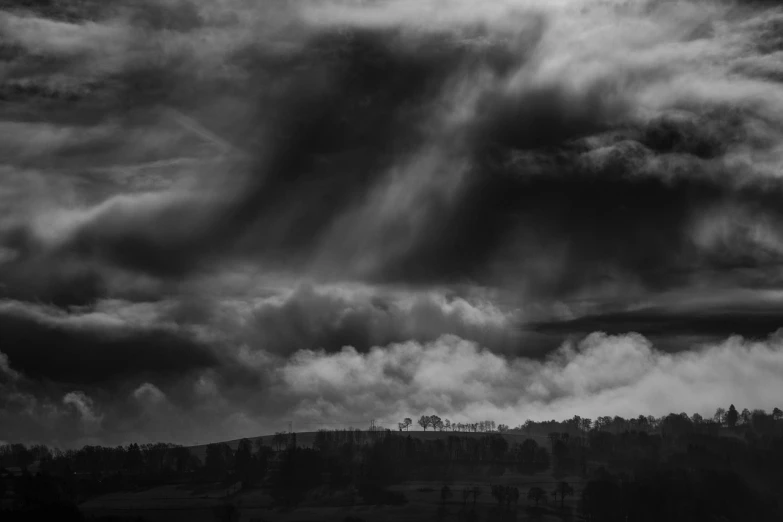 a black and white photo of a cloudy sky, by Andrew Geddes, romanticism, forest plains of north yorkshire, rolling hills, on a dark winter's day, overload