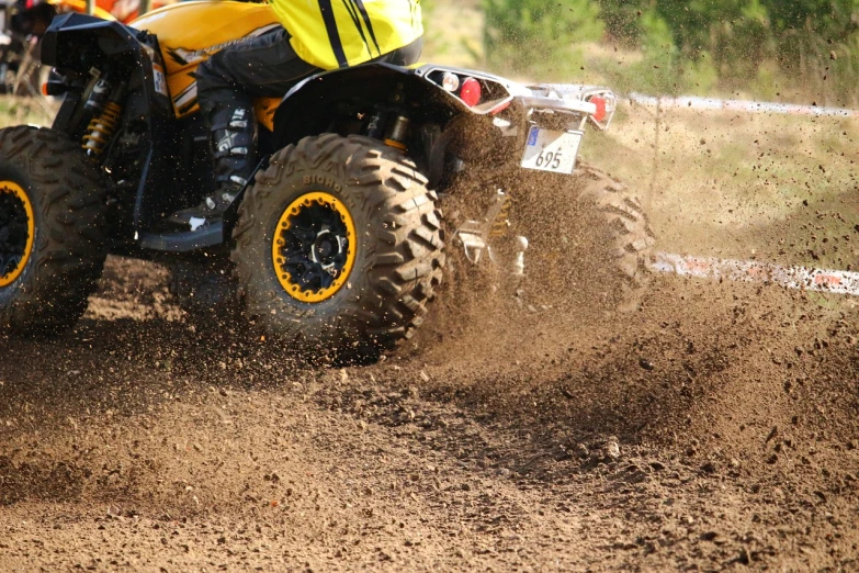 a man riding on the back of a yellow atv, a picture, shutterstock, sand particles, detailed zoom photo, circle pit, high quality product image”