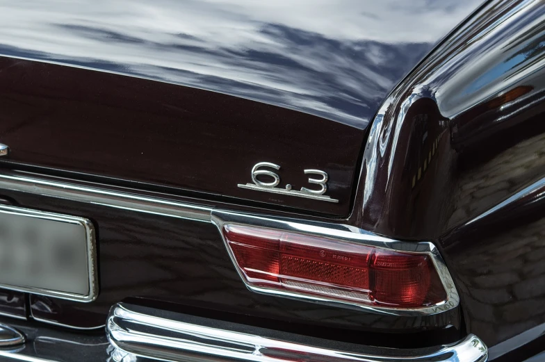 a close up of the rear end of a car, a picture, by Thomas Bock, unsplash, photorealism, 6 0 s style, mercedez benz, triple six, maroon metallic accents