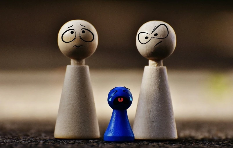 a couple of wooden pegs with faces drawn on them, a picture, by Jesper Knudsen, flickr, purism, stop motion vinyl figure, blues, towering above a small person, his friends are angry