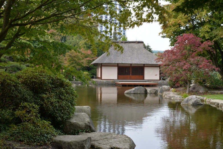 a small building sitting in the middle of a pond, inspired by Tōshi Yoshida, flickr, exterior botanical garden, october, hut, photo from the side