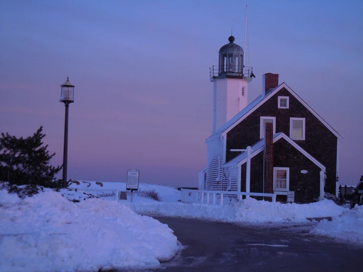 a light house sitting on top of a snow covered hill, by Tom Carapic, flickr, soft purple glow, new england architecture, a road leading to the lighthouse, garner holt