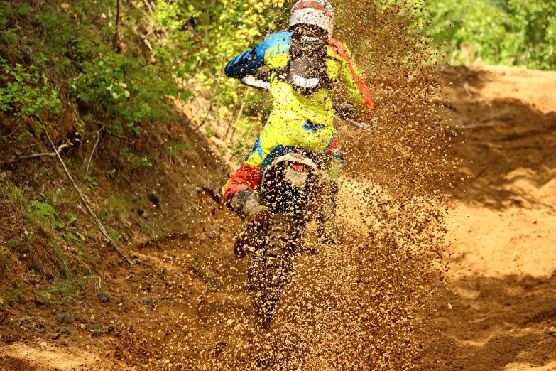 a person riding a dirt bike in the mud, a photo, flickr, vivid colors!!, falling sand inside, lane brown, fine intricate