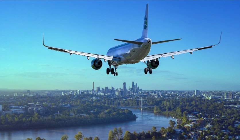 a large passenger jet flying over a city, pixabay contest winner, landing gear, a green, [ [ hyperrealistic ] ], compressed jpeg