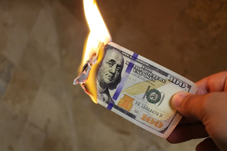 a person holding a burning hundred dollar bill, a picture, by Adam Manyoki, pixabay, auto-destructive art, instagram post, blame, tear drop, room is on fire