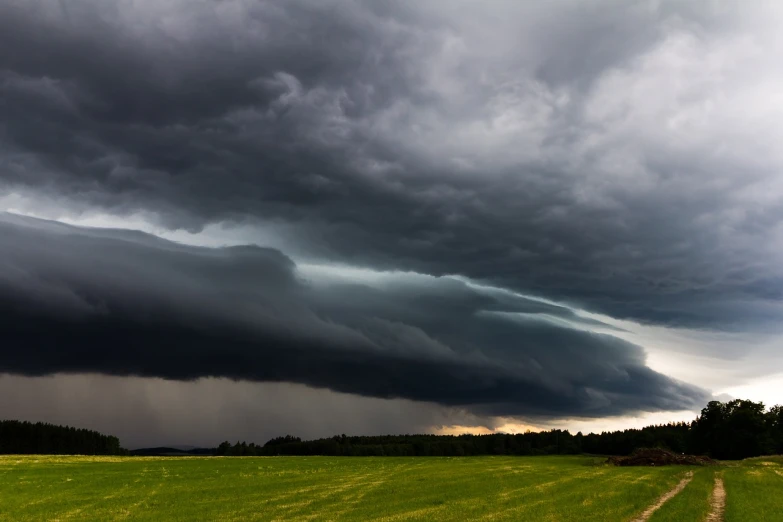 a dark cloud hovers over a green field, a picture, by Thomas Häfner, shutterstock, storm arriving, lined up horizontally, extreme long shot, panspermia