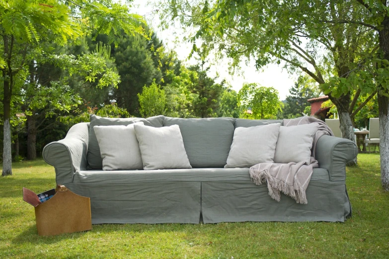 a man sitting on a couch in the grass, inspired by Constantin Hansen, baroque, sage green, upcycled, linen, panorama