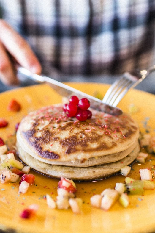 a stack of pancakes sitting on top of a yellow plate, a portrait, shutterstock, squashed berries, avatar image, close - up photo, on a plate in a busy diner