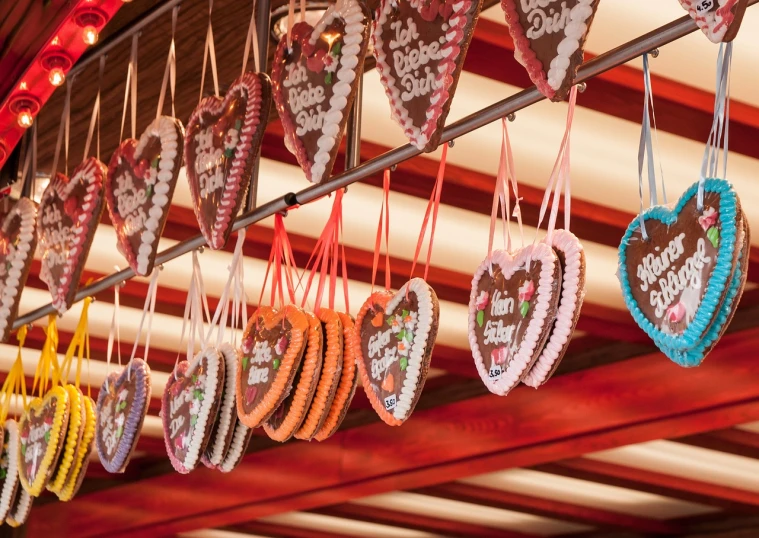 a bunch of heart shaped cookies hanging from a ceiling, by Jakob Gauermann, folk art, colorful signs, closeup photo, ribbon, set photo