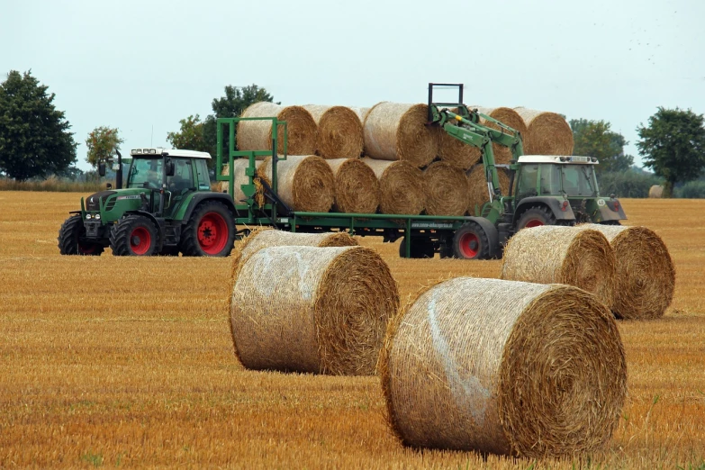a tractor and some hay bales in a field, a picture, shutterstock, afp, round-cropped, detailed picture, journalism photo