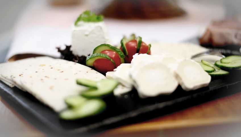 a close up of a plate of food on a table, a picture, by Aleksander Gierymski, flickr, cheeses, high detail product photo, greek ameera al taweel, taken with a pentax k1000