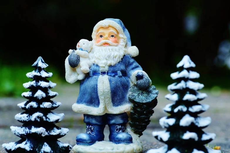 a figurine of a santa claus standing next to a christmas tree, a photo, pixabay, folk art, blue and white tones, outdoor photo, ebay photo, stock photo