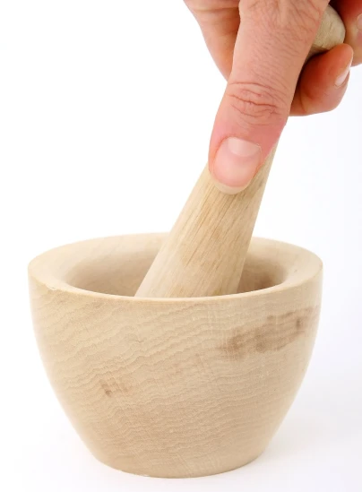 a person holding a wooden mortar brush in a wooden bowl, a stock photo, inspired by Kawai Gyokudō, polished maple, dezeen, 4 0 9 6, pestle
