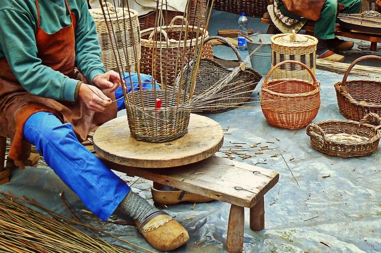 a man sitting on top of a wooden bench, a picture, by Raymond Coxon, trending on pixabay, arts and crafts movement, weaving, guangjian, market setting, [ closeup ]!!