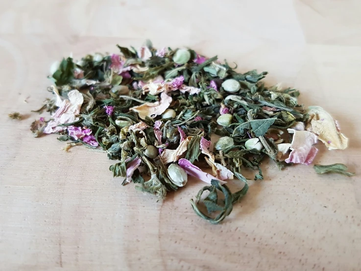 a pile of dried flowers sitting on top of a wooden table, a picture, green tea, draped in fleshy green and pink, half moon, detailed!