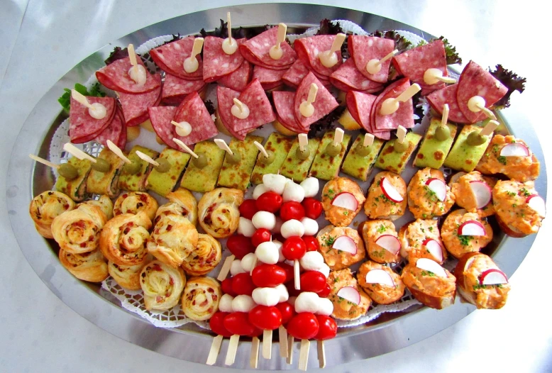 a platter filled with different types of appetizers, a picture, by Antonio Rotta, flickr, skewer, foil, symmetrical, reds