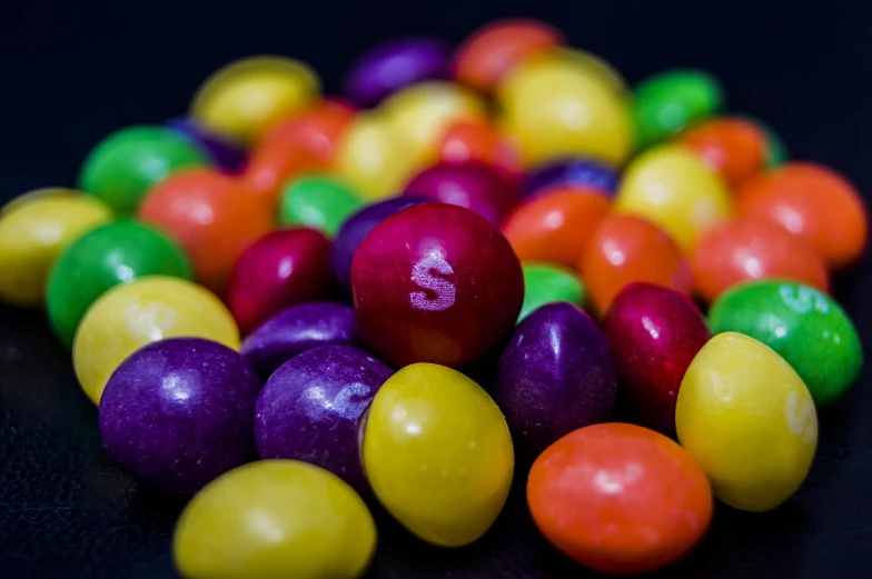 a pile of colorful candy sitting on top of a table, a picture, by Arnie Swekel, letter s, rich color, inputs, shallow focus