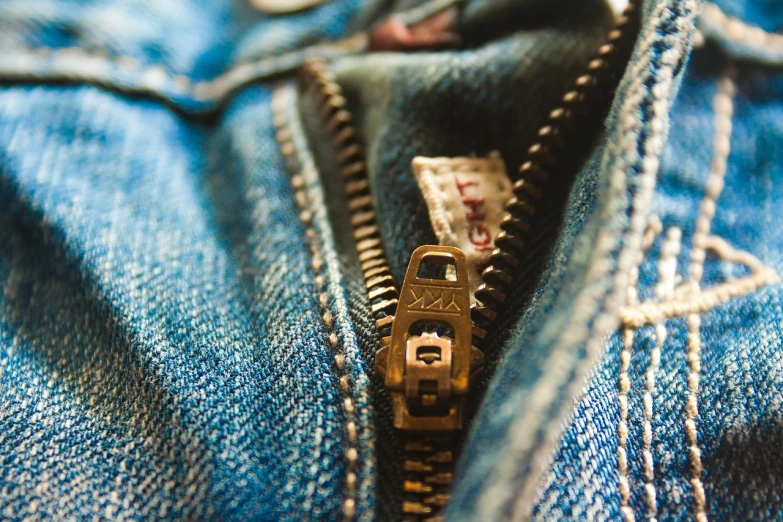 a close up of a zipper on a pair of jeans, by Daniel Ljunggren, pexels, vintage levi ’ s ad, hyperrealistic flickr:5, golden details!, tiltshift