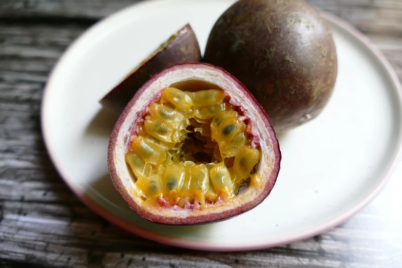 a passion fruit cut in half on a plate, by Harvey Pratt, flickr, hurufiyya, with fruit trees, smooth waxy skin, けもの, garnet