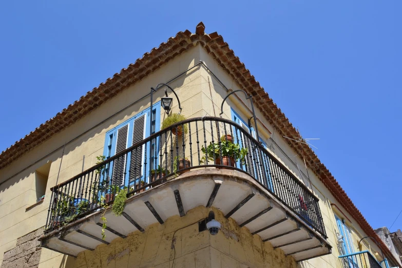 a building with a balcony and balconies on it, pixabay, agrigento, puerto rico, airbnb, corner