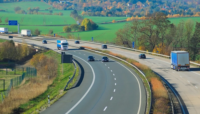 a group of trucks traveling down a highway, by Thomas Häfner, pixabay, roads among fields, lower saxony, car on highway, on a sunny day