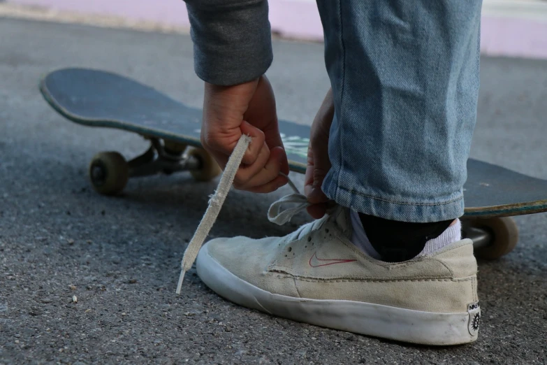 a person tying a shoelacee on a skateboard, chalk white skin, long hook nose, dylan kowalski, soft white rubber
