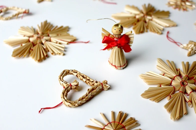 a close up of a christmas ornament on a table, a picture, folk art, straw, angels, set pieces, on a white background