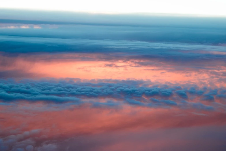 an airplane is flying high above the clouds, romanticism, pink and blue colors, layered stratocumulus clouds, the colours of the sunset, blue and white and red mist