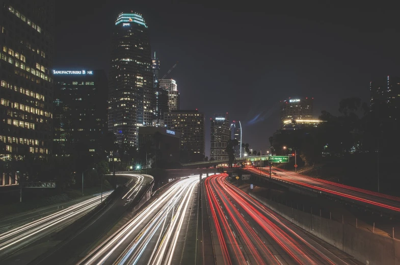 a city street filled with lots of traffic at night, by Josh Bayer, unsplash contest winner, digital art, southern california, skyline, freeway, shot with a canon 20mm lens