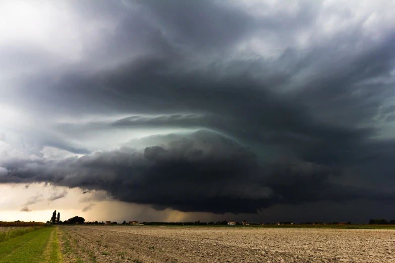 a large black cloud is in the sky over a field, a picture, by Daniel Seghers, shutterstock, hurricane stromy clouds, heavy vignette!, hull, panspermia