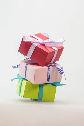 a stack of three gift boxes sitting on top of each other, by Richard Carline, pixabay, set against a white background, birthday wrapped presents, miniature product photo, pastel