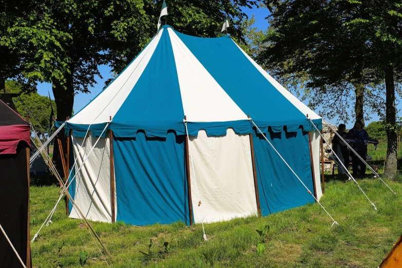 a blue and white tent sitting on top of a lush green field, by Edward Corbett, shutterstock, renaissance, tournament, circular, exterior shot, teal