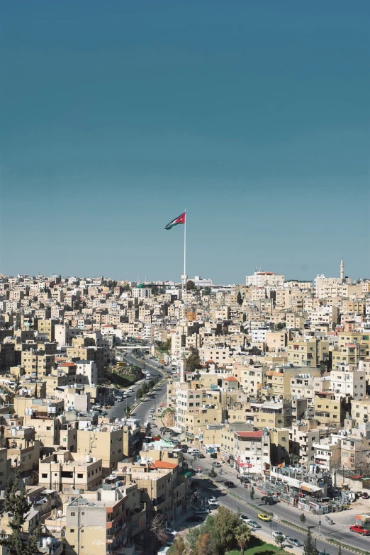 a large city filled with lots of tall buildings, by Ibram Lassaw, hurufiyya, flag, jordan, high detailed photo, from far away