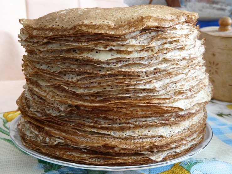 a stack of pancakes sitting on top of a plate, by Aleksander Gierymski, flickr, renaissance, several layers of fabric, siberia!!, crackles, grain”