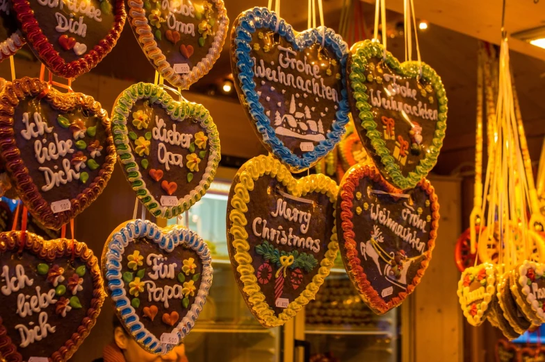 a bunch of heart shaped cookies hanging from the ceiling, by Jakob Gauermann, folk art, colorful signs, christmas, closeup - view, very detailed photo