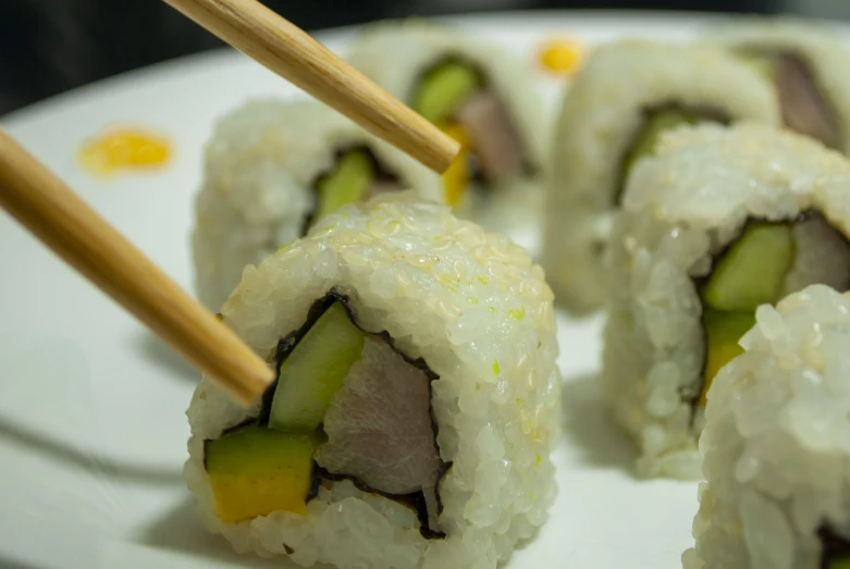 a white plate topped with sushi and chopsticks, inspired by Maki Haku, duck, avocado, wikimedia commons, close - up photo