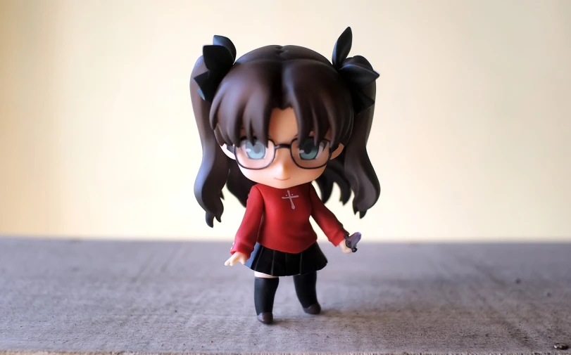 a close up of a doll on a table, by Jin Homura, flickr, magic school uniform, !!wearing glasses!!, rin tohsaka, chibi proportions