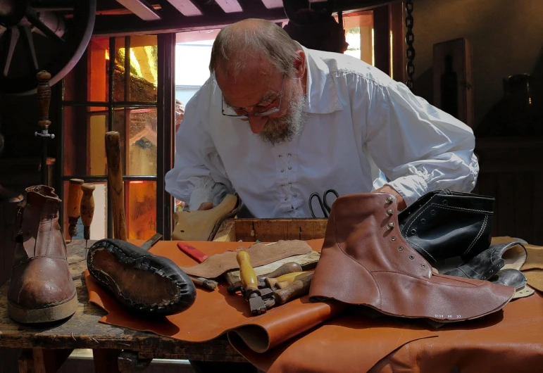 a man working on a piece of leather, inspired by Hans Holbein the Elder, renaissance, wearing military shoes, photo taken in 2018, new mexico, old man