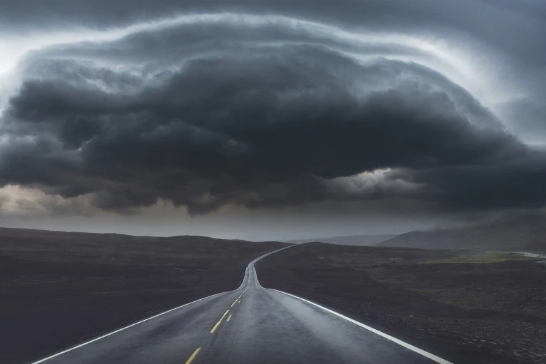 a black and white photo of a road under a cloudy sky, a picture, by Jesper Knudsen, pexels contest winner, surrealism, eye of the storm, mikko lagerstedt, curving, dark mammatus cloud