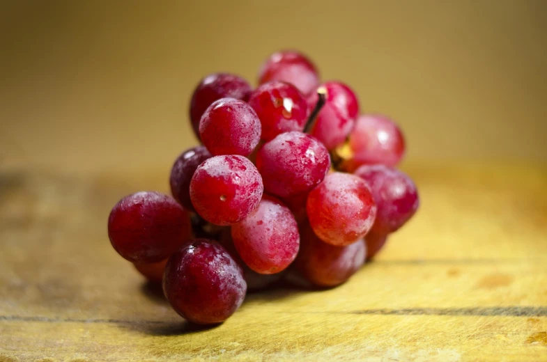 a bunch of grapes sitting on top of a wooden table, a picture, by Julian Allen, red colored, ready to eat, high quality product image”, photo - shot