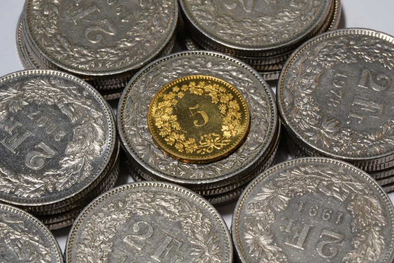a pile of coins sitting on top of each other, a macro photograph, by Joseph von Führich, art nouveau, silver and yellow color scheme, swiss, high quality product image”, dividing it into nine quarters