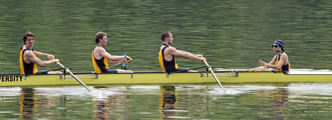 a group of men riding on top of a yellow boat, a picture, pixabay, sculls, sport, two male, pittsburgh