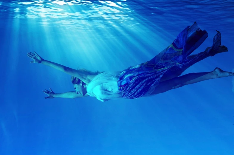 a man swimming under the surface of the water, a picture, happening, blue swirling dress, full res, beautiful lady, ray