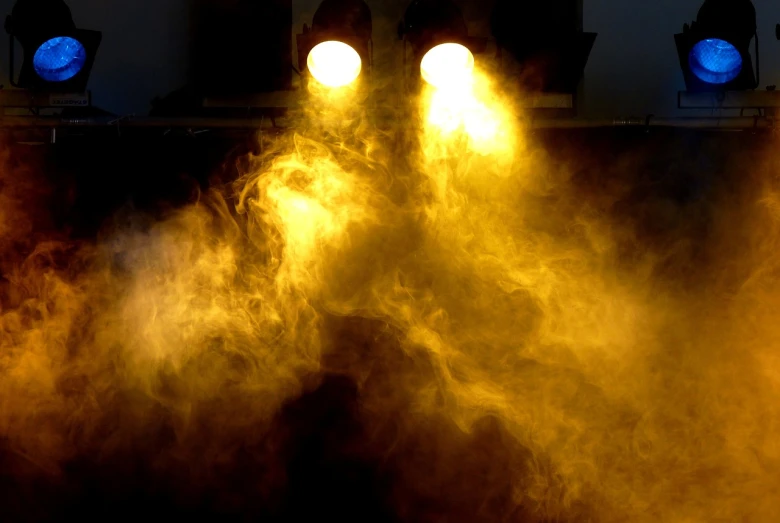 a couple of lights that are on top of a table, flickr, precisionism, sweaty. steam in air, warm yellow lighting, muzzle flash, ( ( stage lights ) )